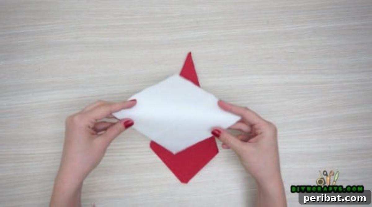 5 DIY Christmas Napkin Designs: Festive Folds, Easy Video How-To 3 Santa Napkin - Prepare the white napkin for Santa's beard in this Christmas table setting idea.