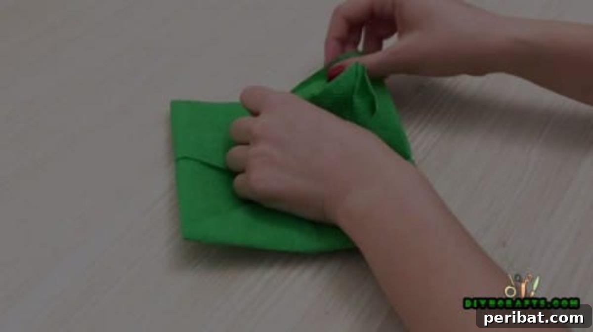 5 DIY Christmas Napkin Designs: Festive Folds, Easy Video How-To 21 Fancy Napkin - Pull corners up and out to form petal shapes for stunning Christmas napkin fold.