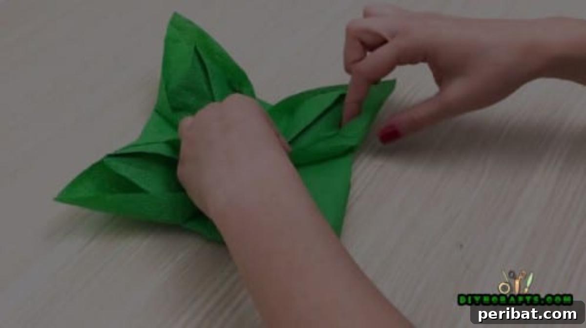 5 DIY Christmas Napkin Designs: Festive Folds, Easy Video How-To 23 Fancy Napkin - Finalizing petal shapes for a sophisticated and beautiful Christmas table setting.
