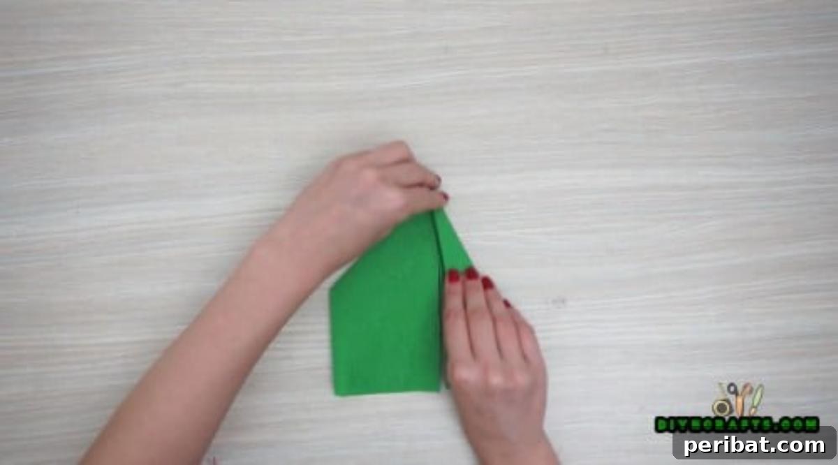 5 DIY Christmas Napkin Designs: Festive Folds, Easy Video How-To 28 Elf Boot Napkins - Fold both edges inward to center, shaping the elf boot for Christmas decor.