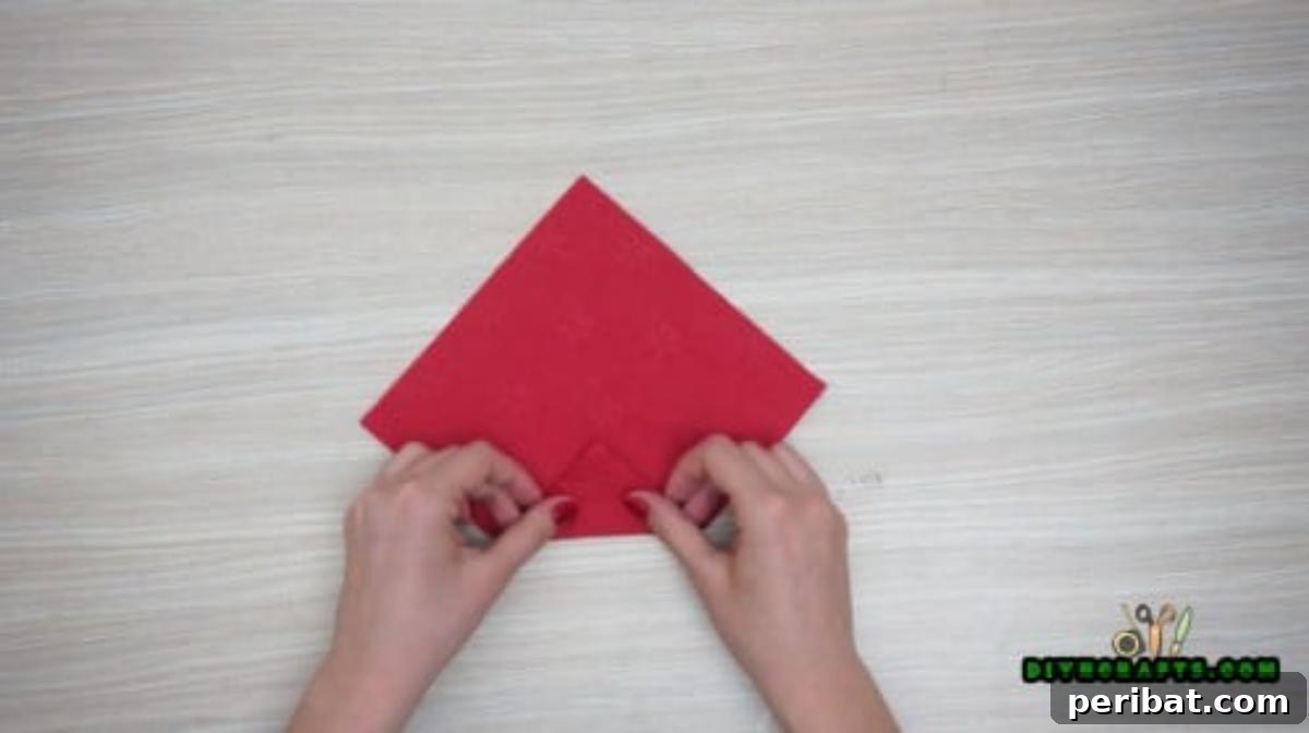 5 DIY Christmas Napkin Designs: Festive Folds, Easy Video How-To 33 Christmas Hat Napkin - Fold bottom corner not quite to center, forming Christmas hat shape.