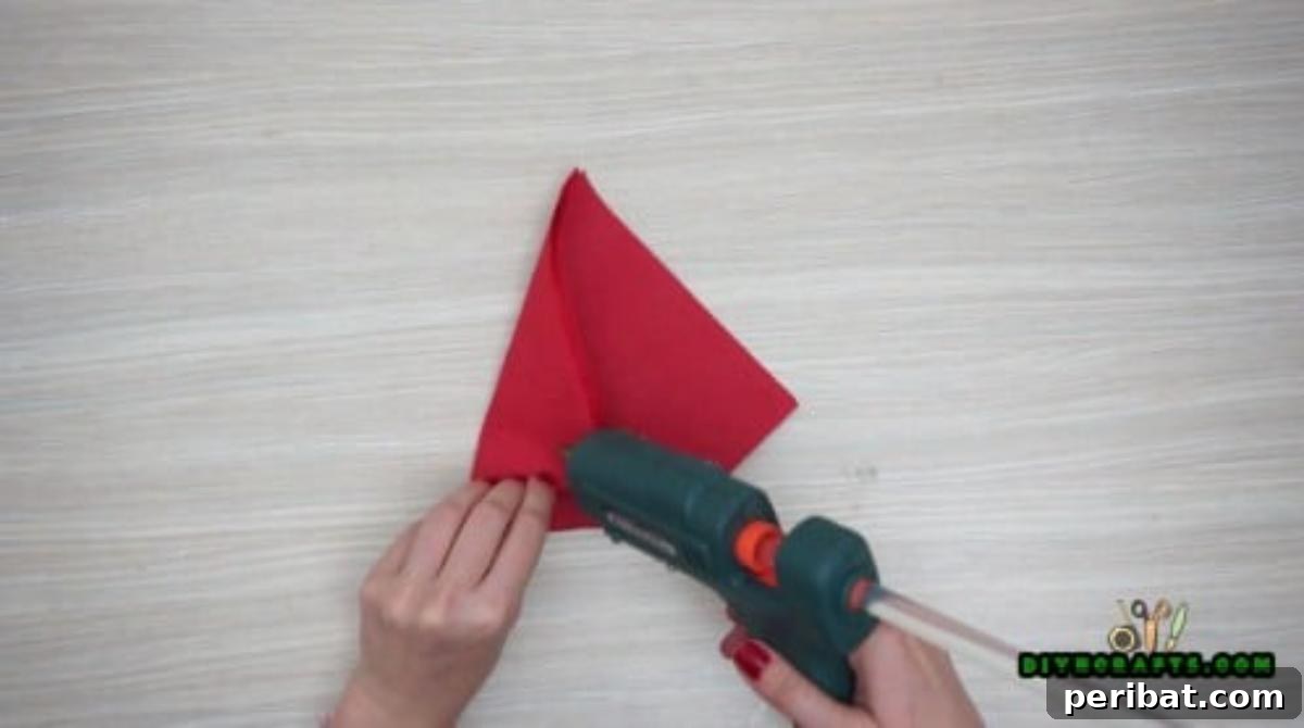 5 DIY Christmas Napkin Designs: Festive Folds, Easy Video How-To 34 Christmas Hat Napkin - Fold in edges and glue to form a triangular Christmas hat, simple decor.