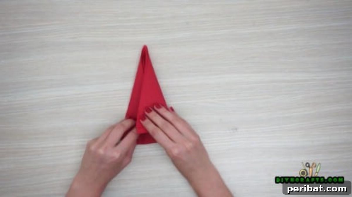 5 DIY Christmas Napkin Designs: Festive Folds, Easy Video How-To 35 Christmas Hat Napkin - Secure glued edges for a perfectly shaped Christmas hat napkin fold.