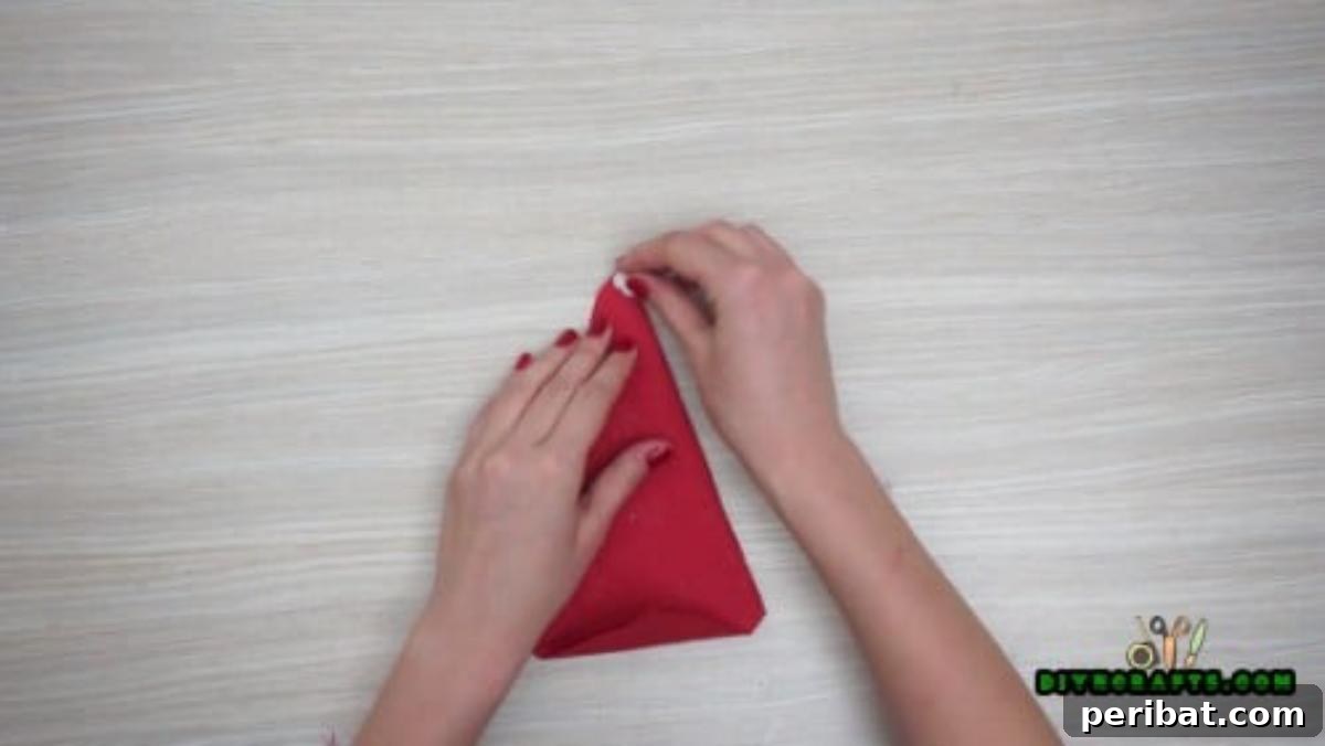5 DIY Christmas Napkin Designs: Festive Folds, Easy Video How-To 36 Christmas Hat Napkin - Glue a cotton ball to the hat tip for a classic, festive Christmas hat.