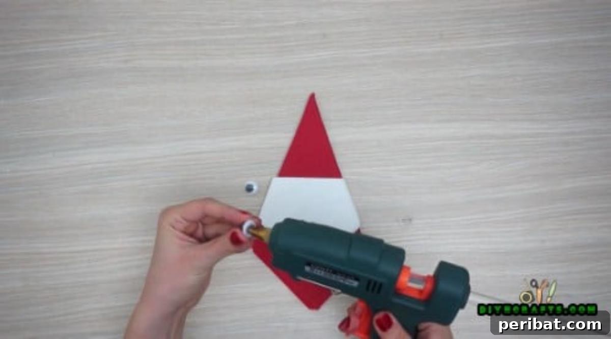 5 DIY Christmas Napkin Designs: Festive Folds, Easy Video How-To 6 Santa Napkin - Add googly eyes to complete your adorable Santa napkin, perfect for Christmas parties.