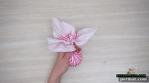 Effortless Holiday Crafting 5 DIY Ornament Videos 41 Close up of tissue paper gathered around the craft ball
