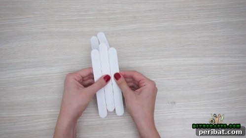 Effortless Holiday Crafting 5 DIY Ornament Videos 6 Close up of three glued craft sticks for sleigh base