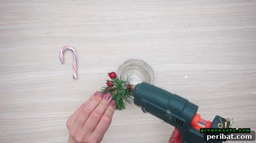 5 Frugal & Festive Christmas Jar Decorations 26 Step 2: Attach a fake holly sprig or a bundle of fake pine needles to the lace on the jar.