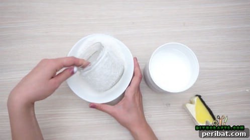 5 Frugal & Festive Christmas Jar Decorations 35 Step 3: Roll or dip the glued jar into craft snow, ensuring complete coverage.