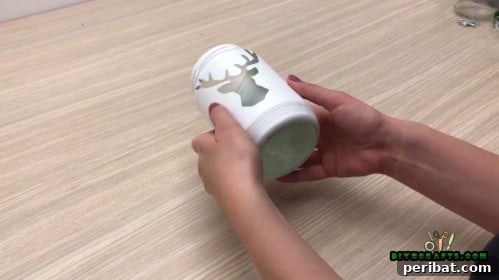 5 Frugal & Festive Christmas Jar Decorations 6 Step 3: Carefully remove the reindeer cutout to reveal the clear glass shape underneath the paint.