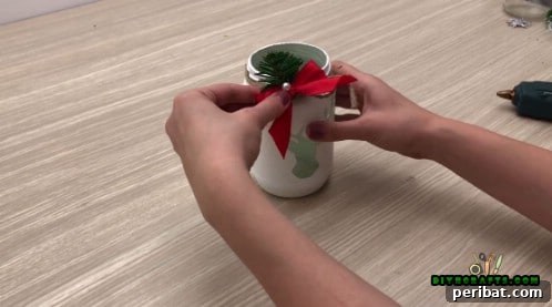 5 Frugal & Festive Christmas Jar Decorations 8 Step 5: Decorate the jar further with a small bow, fake pine needles, and a faux pearl, or other chosen embellishments.