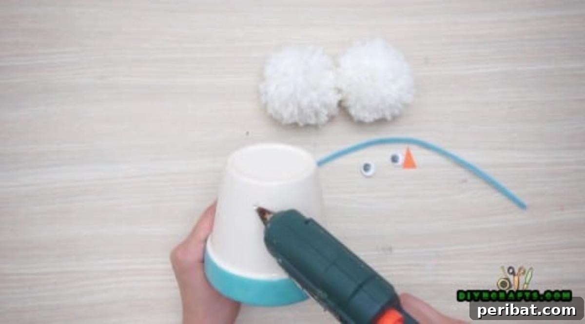Minute-Made Snowmen: 5 Speedy & Creative Crafts 11 Hot gluing googly eyes onto the inverted plastic cup snowman base