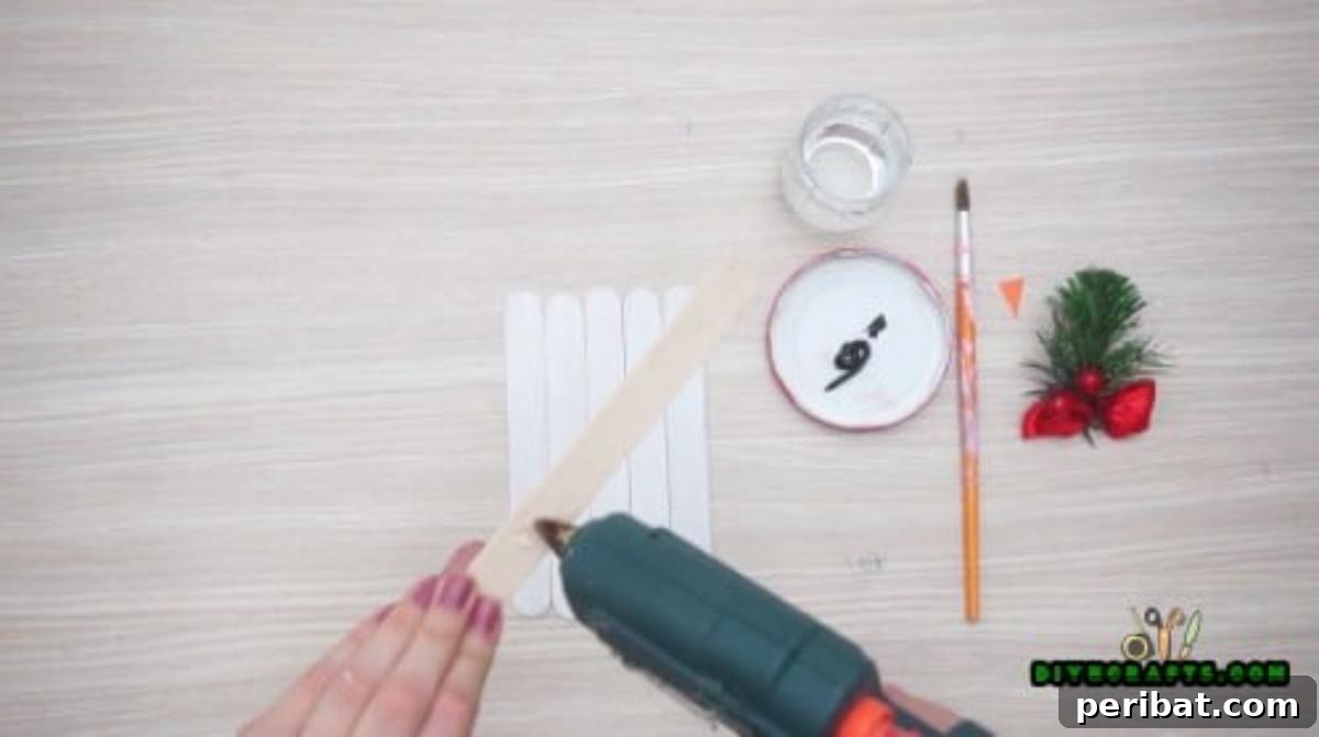 Minute-Made Snowmen: 5 Speedy & Creative Crafts 3 Five craft sticks aligned, with a sixth diagonal stick glued across the top, forming the base for a snowman craft