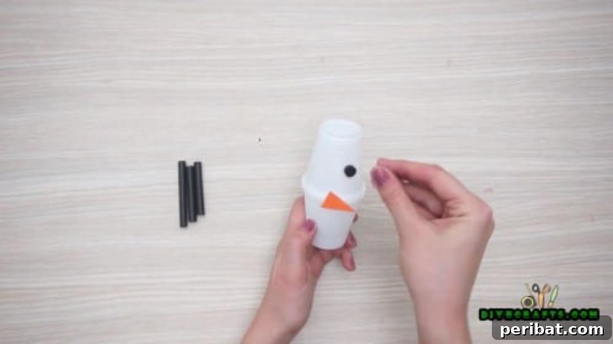 Minute-Made Snowmen: 5 Speedy & Creative Crafts 21 Hot gluing button eyes onto the plastic cup snowman