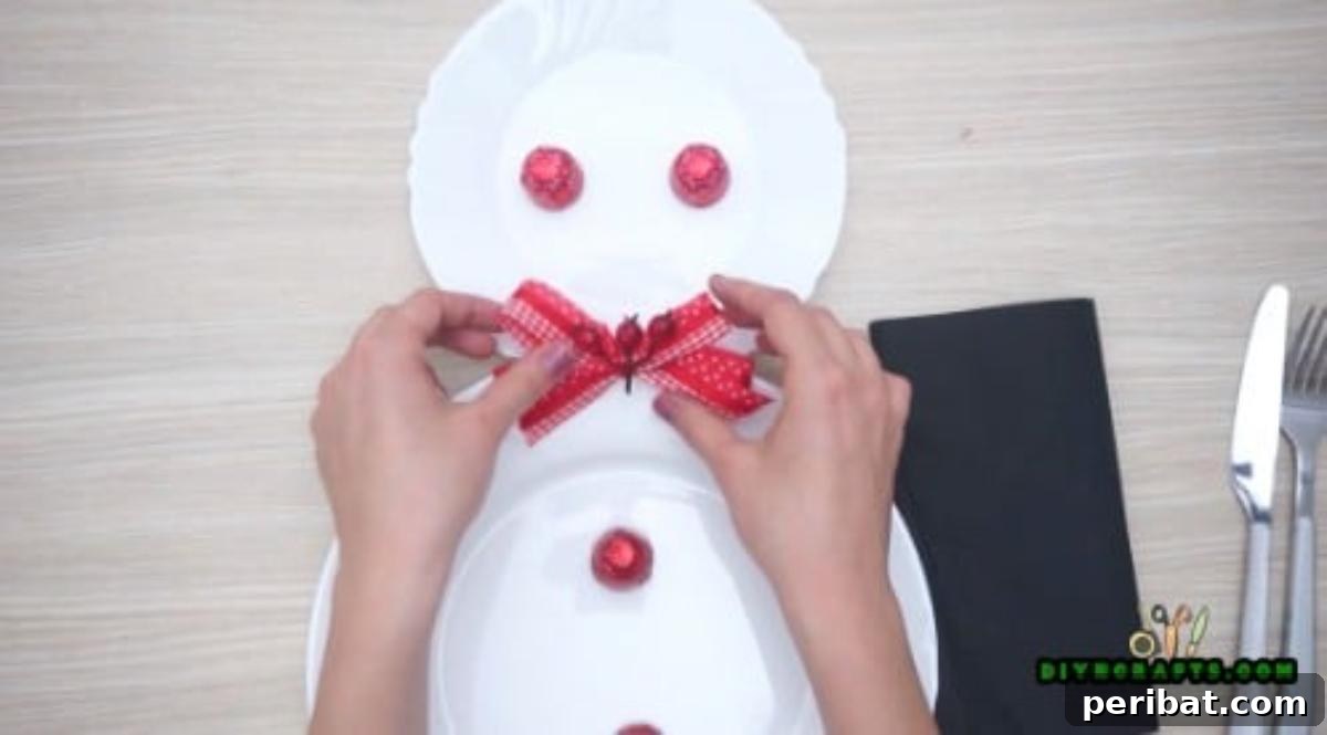Minute-Made Snowmen: 5 Speedy & Creative Crafts 26 Candies arranged on the larger plate as snowman buttons, with a bow added to the smaller plate
