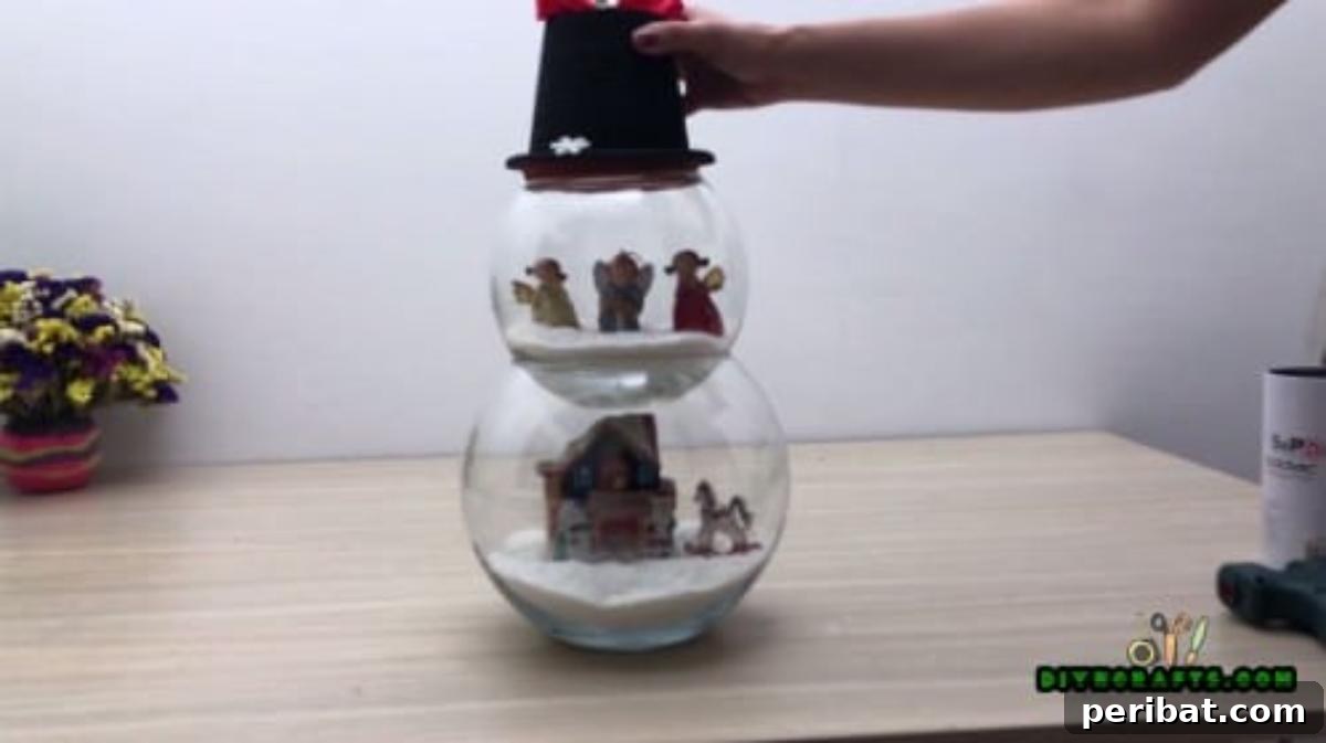 Minute-Made Snowmen: 5 Speedy & Creative Crafts 36 Side view of the completed fishbowl snowman centerpiece with stacked bowls, figurines, and a hat