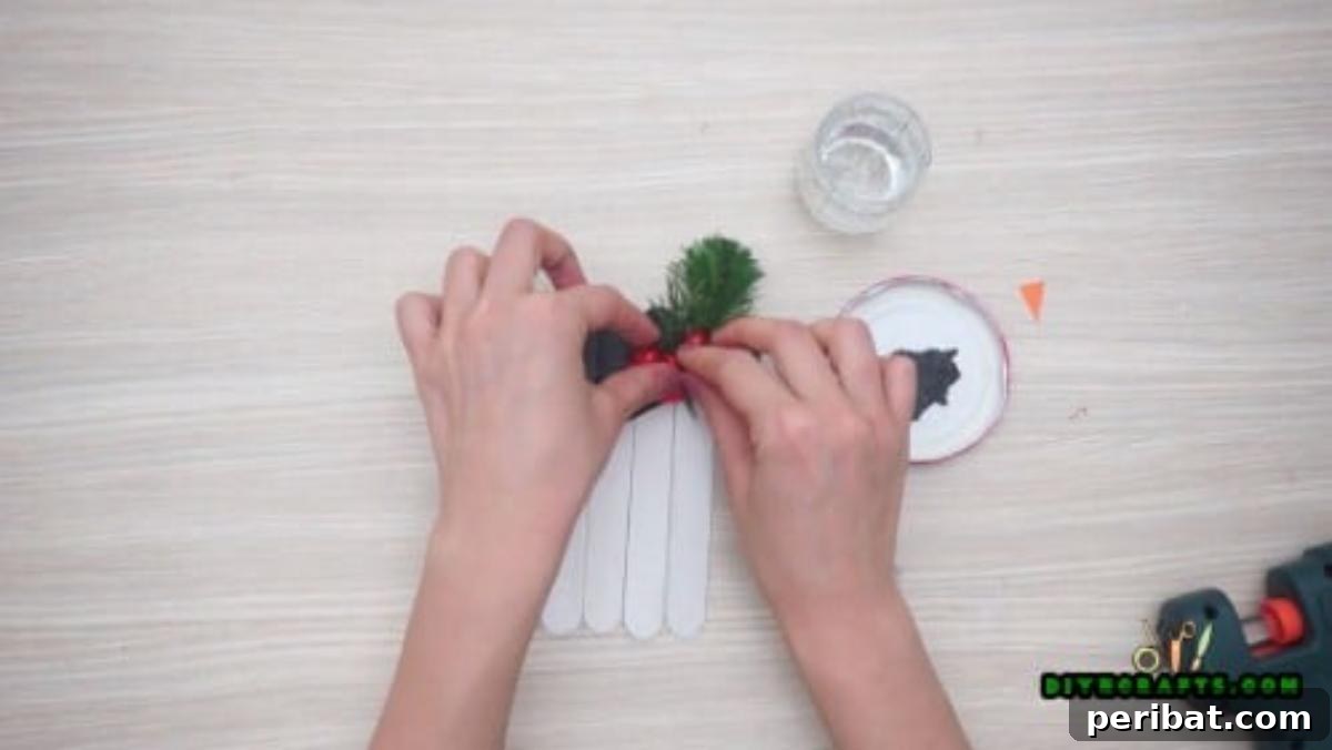 Minute-Made Snowmen: 5 Speedy & Creative Crafts 6 Black-painted craft stick snowman hat adorned with a faux pine branch and red berries