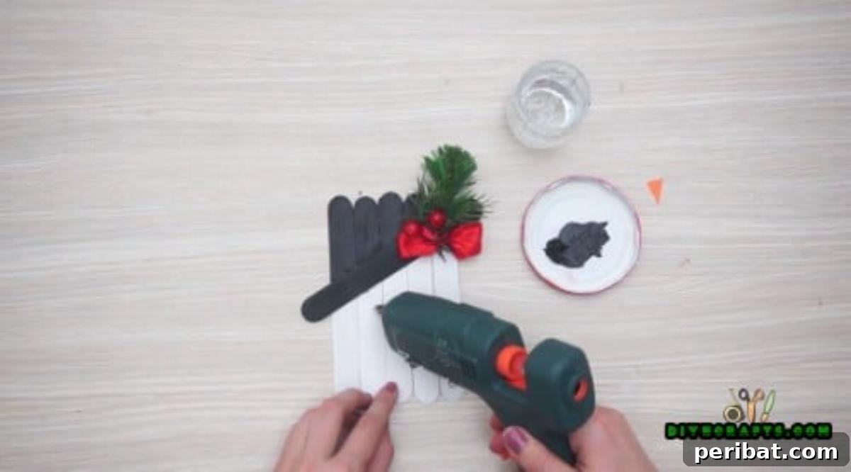 Minute-Made Snowmen: 5 Speedy & Creative Crafts 7 Attaching black buttons to the craft stick snowman for eyes with hot glue