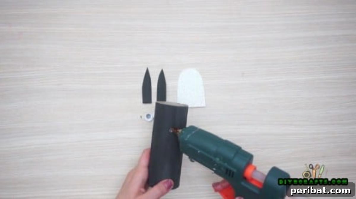 Upcycle Paper Rolls: 5 Easy Holiday Decoration Ideas 21 Cute Penguin - Step 2: Attaching googly eyes to the black paper roll