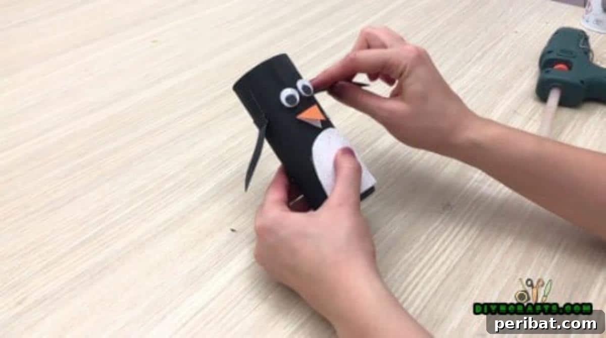 Upcycle Paper Rolls: 5 Easy Holiday Decoration Ideas 24 Cute Penguin - Step 5: Attaching black paper flaps for wings