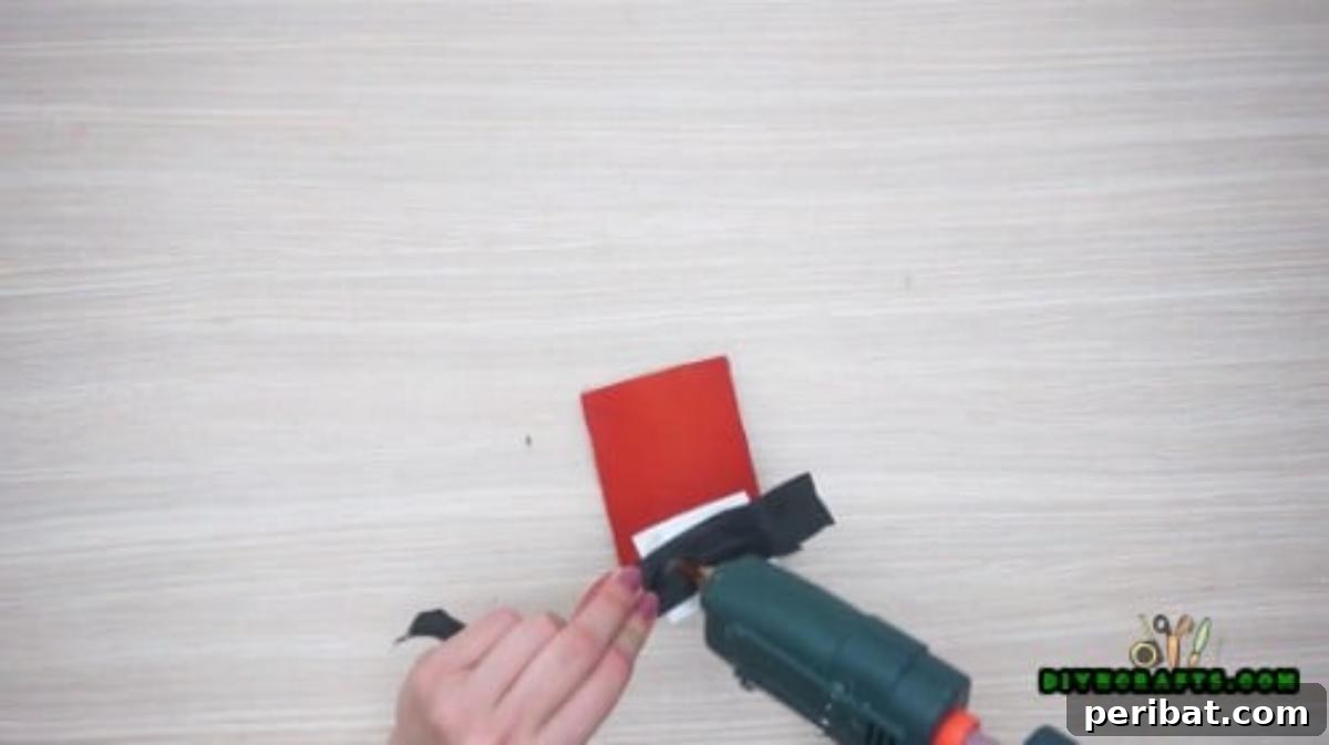Upcycle Paper Rolls: 5 Easy Holiday Decoration Ideas 10 Napkin Ring - Step 3: Attaching black ribbon to the paper roll