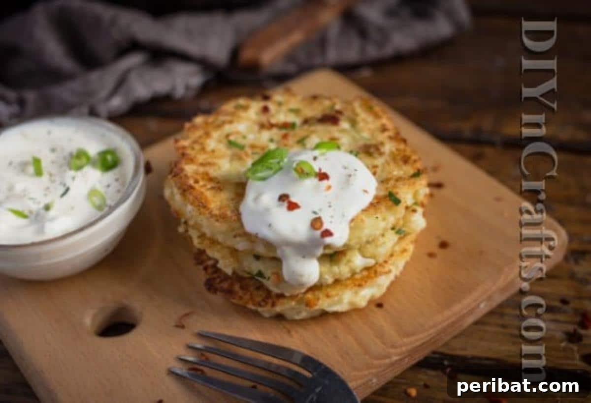 Cauliflower Fritters: The Guilt-Free Upgrade to a Beloved Classic 6 Plated cauliflower fritters garnished with green onions and a side of sour cream, ready to be served.