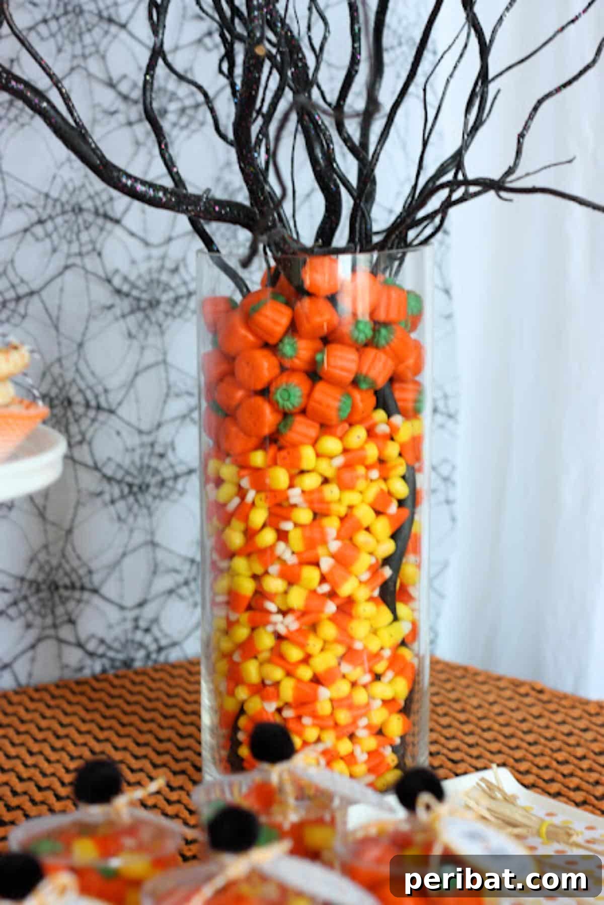 40 Spooktacularly Simple DIY Halloween Decorations 45 DIY Candy Centerpiece with candy corn, candy pumpkins, and a black branch