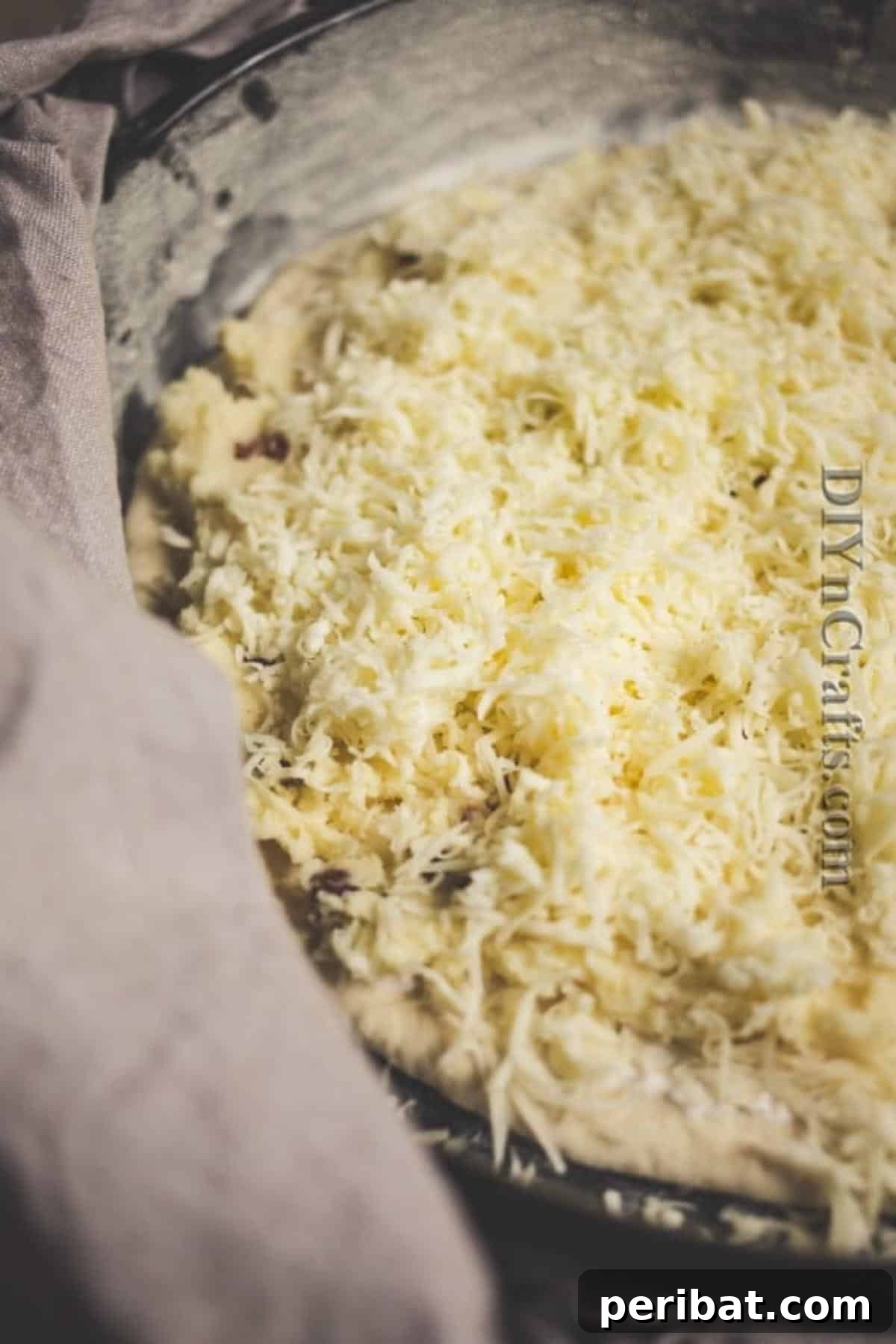 Upgrade Your Snack Game with Pierogi Pizza 5 Spreading potato filling onto a premade pizza crust and topping with cheese
