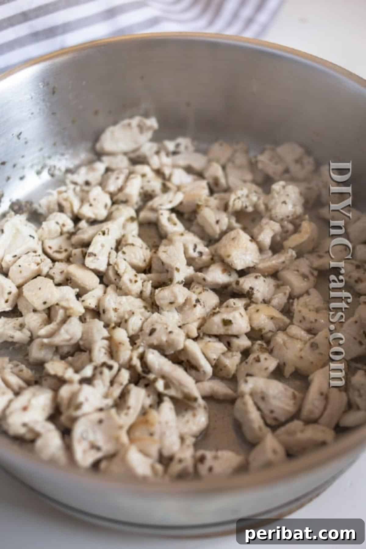 The Ultimate Easy Skillet Chicken Pasta 4 Close-up of chicken breast pieces browning in olive oil with salt and oregano in a skillet.
