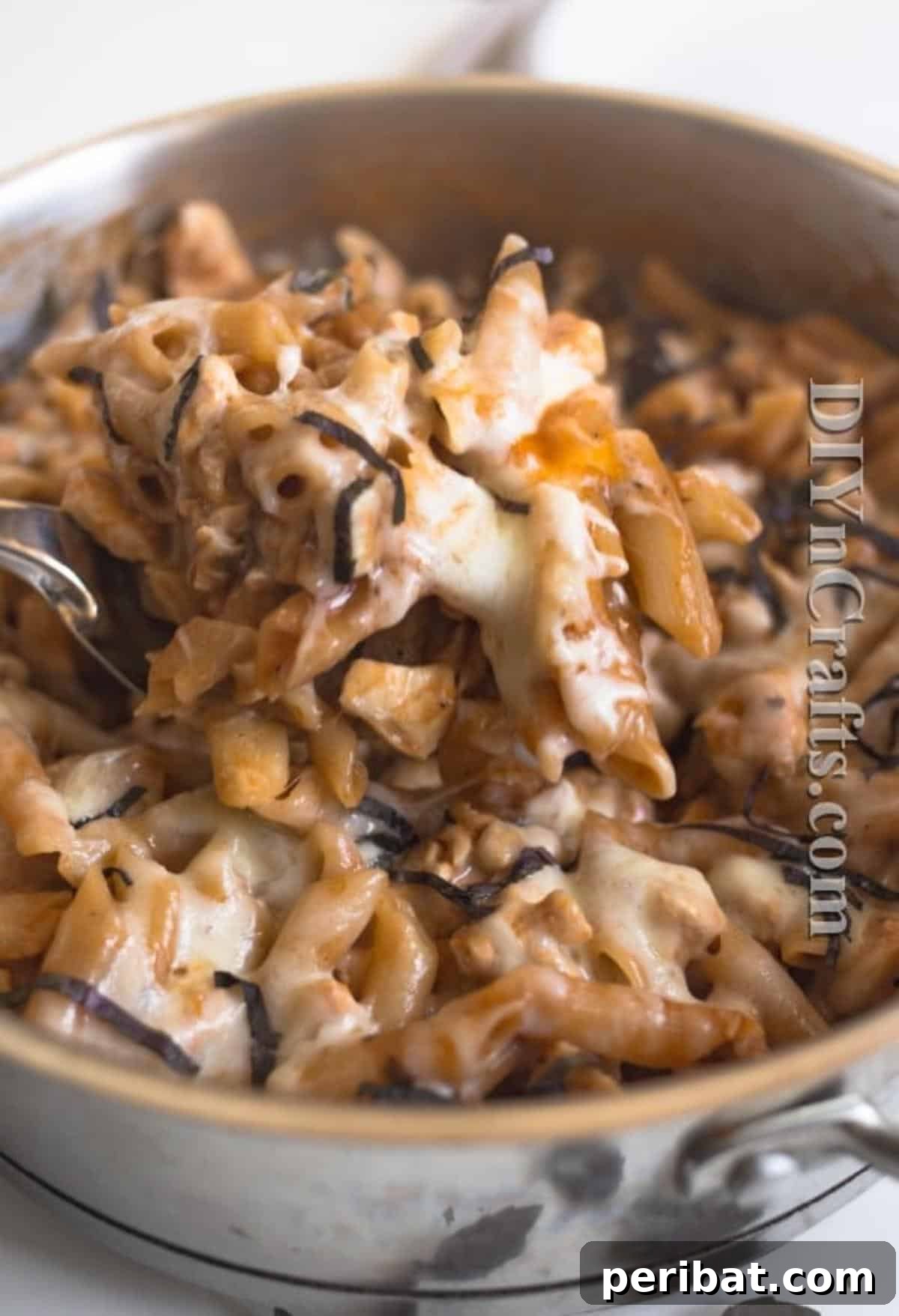 The Ultimate Easy Skillet Chicken Pasta 7 A serving of the finished chicken pasta skillet in a bowl, garnished with fresh basil, showcasing its appetizing appeal.