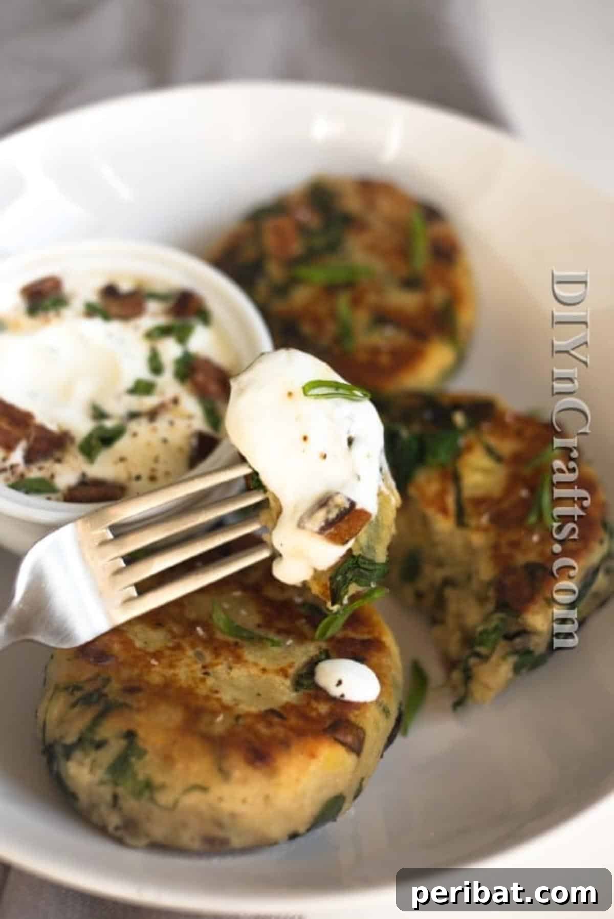 Reimagined Potato Spinach Patties A Delicious Classic 7 Plated potato spinach patties topped with sour cream, garnished with fresh herbs