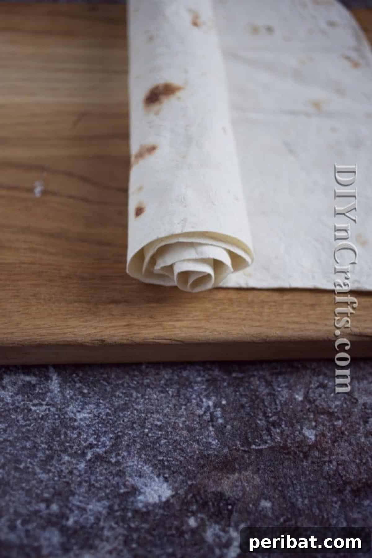Slicing the rolled tortilla to create perfectly shaped cheese pinwheels