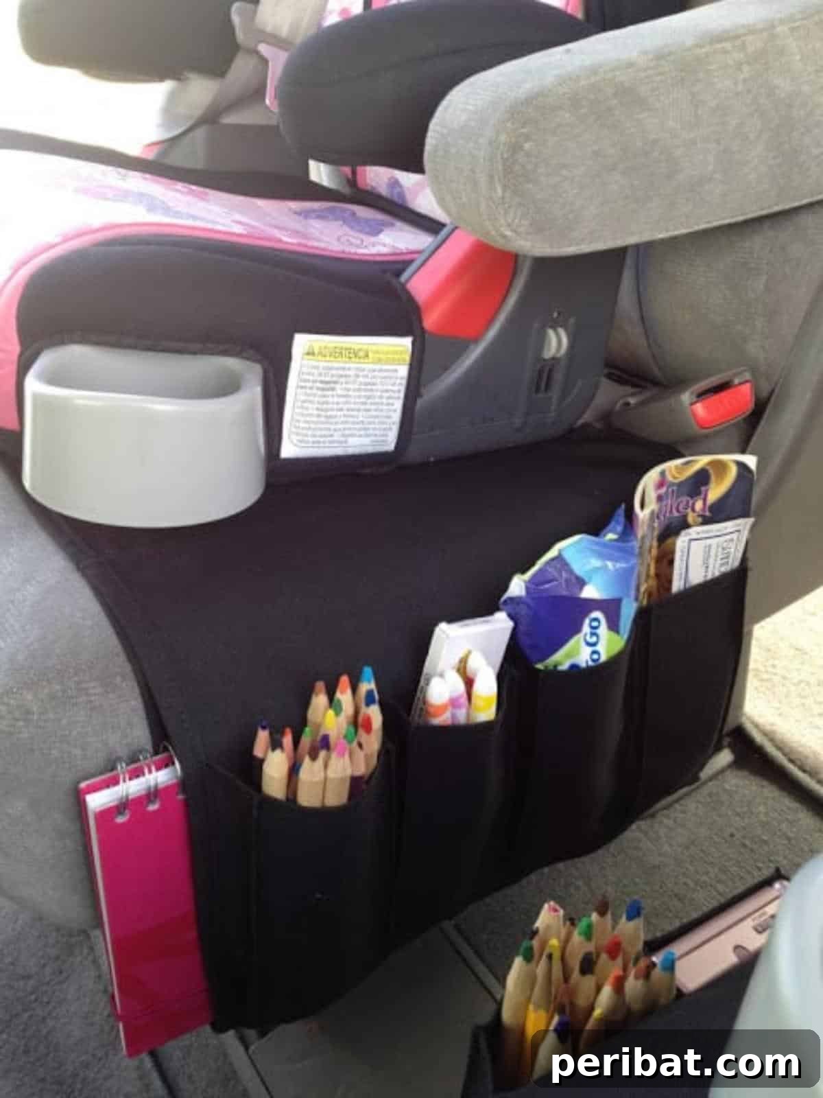 Effortless DIY Car Organization Hacks 3 An IKEA Flort remote holder repurposed as a backseat car organizer for kids, neatly storing toys, books, and crayons, while also protecting the car seat.