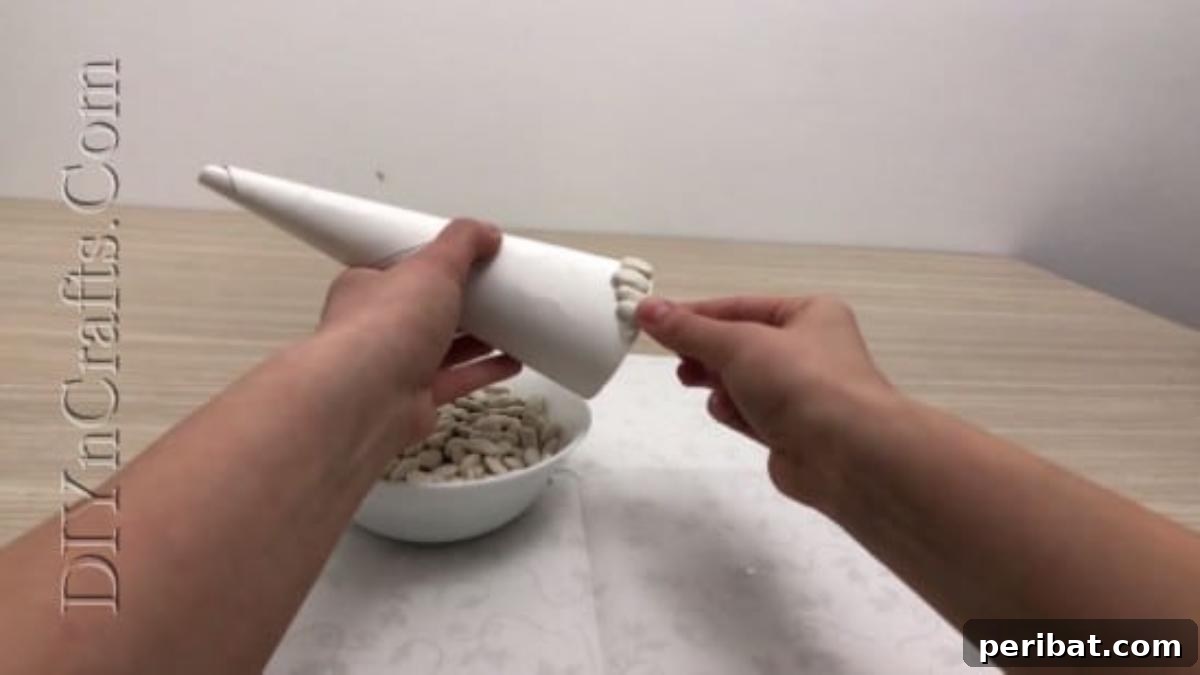 Beans being carefully applied to the cone, building up the unique texture.