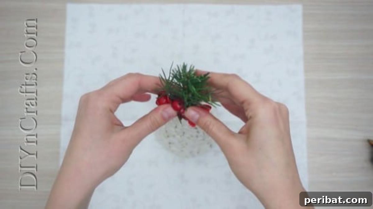 Embellishing the bean Christmas tree with small decorative elements.