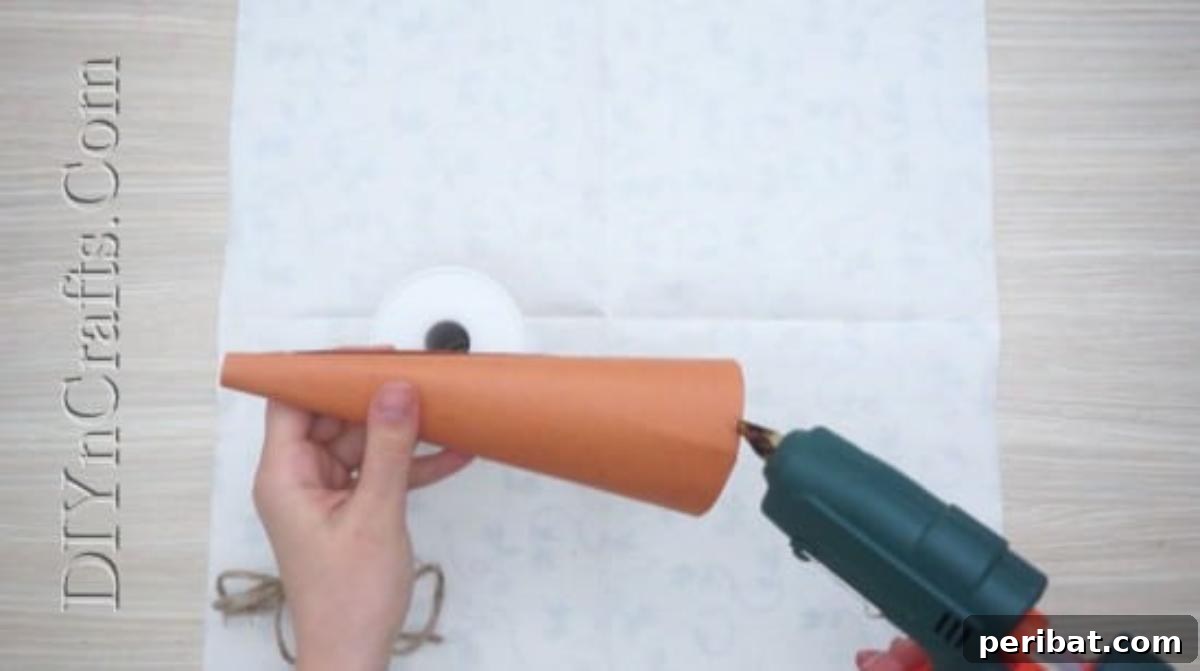 Attaching twine with hot glue, wrapping it carefully around the paper cone.