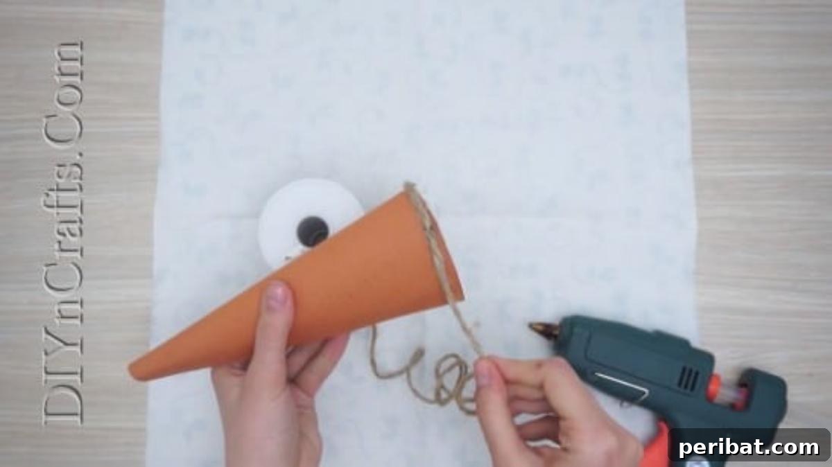 Close-up of twine being wrapped around the paper cone, ensuring tight coils.