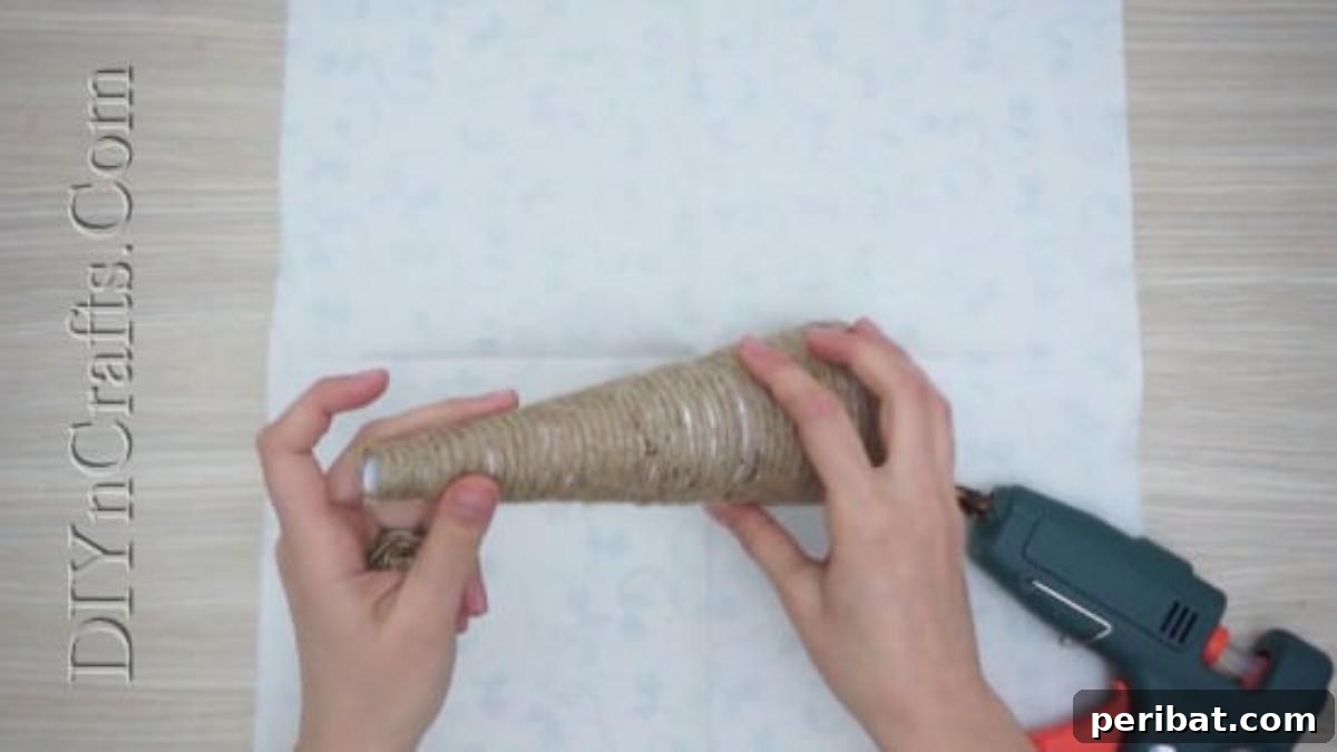 The twine-wrapped cone is nearly complete, showcasing the textured surface.