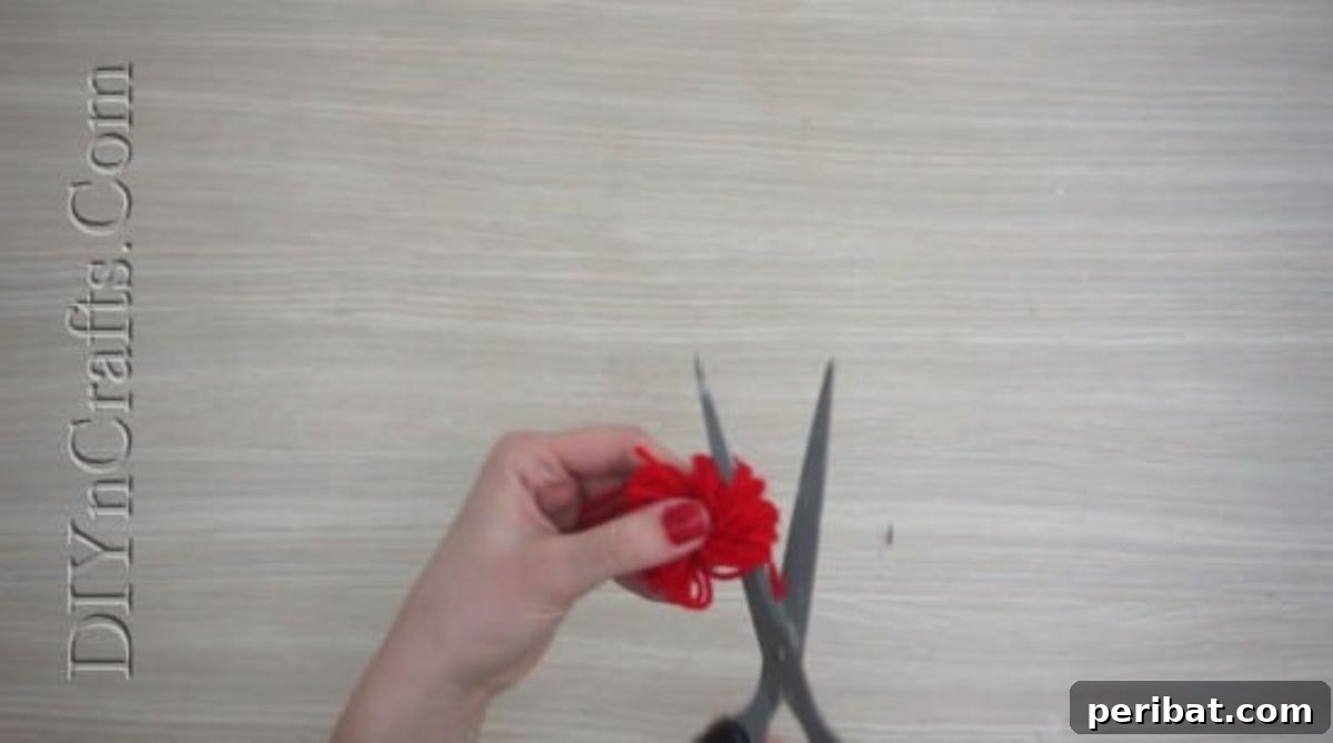 Gift Box - Cutting the loops of a yarn bundle to create a pom-pom for festive Christmas decorations