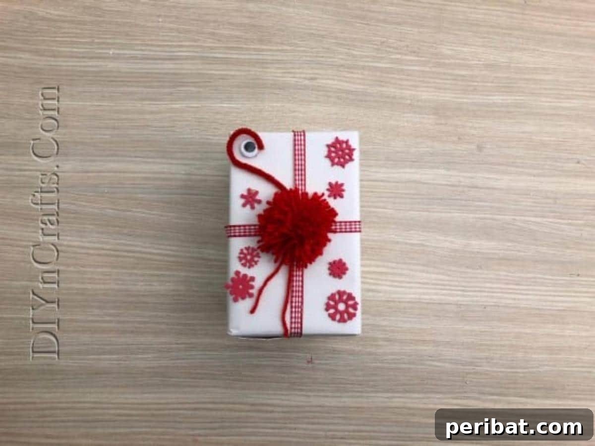 Gift Box - The completed festive gift box with a fluffy pom-pom topper and ribbons