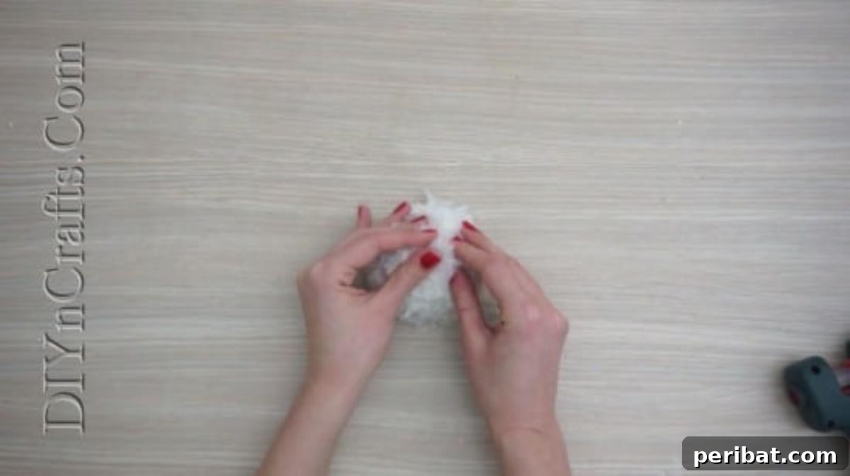 Snowman - The smaller pom-pom glued atop the larger one, forming the snowman's body and head