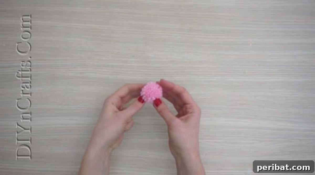 Bookmark - A colorful yarn pom-pom, freshly made and ready to become a Christmas bookmark