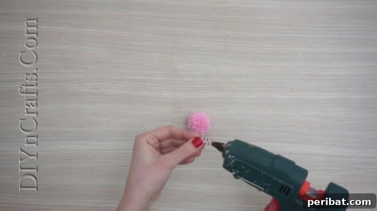 Bookmark - Attaching the pom-pom to the paper clip with hot glue for the Christmas bookmark craft