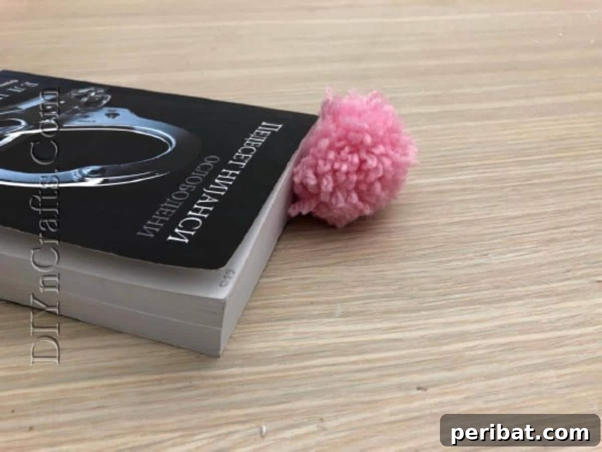 Bookmark - The fluffy pom-pom bookmark elegantly marking a page in a book