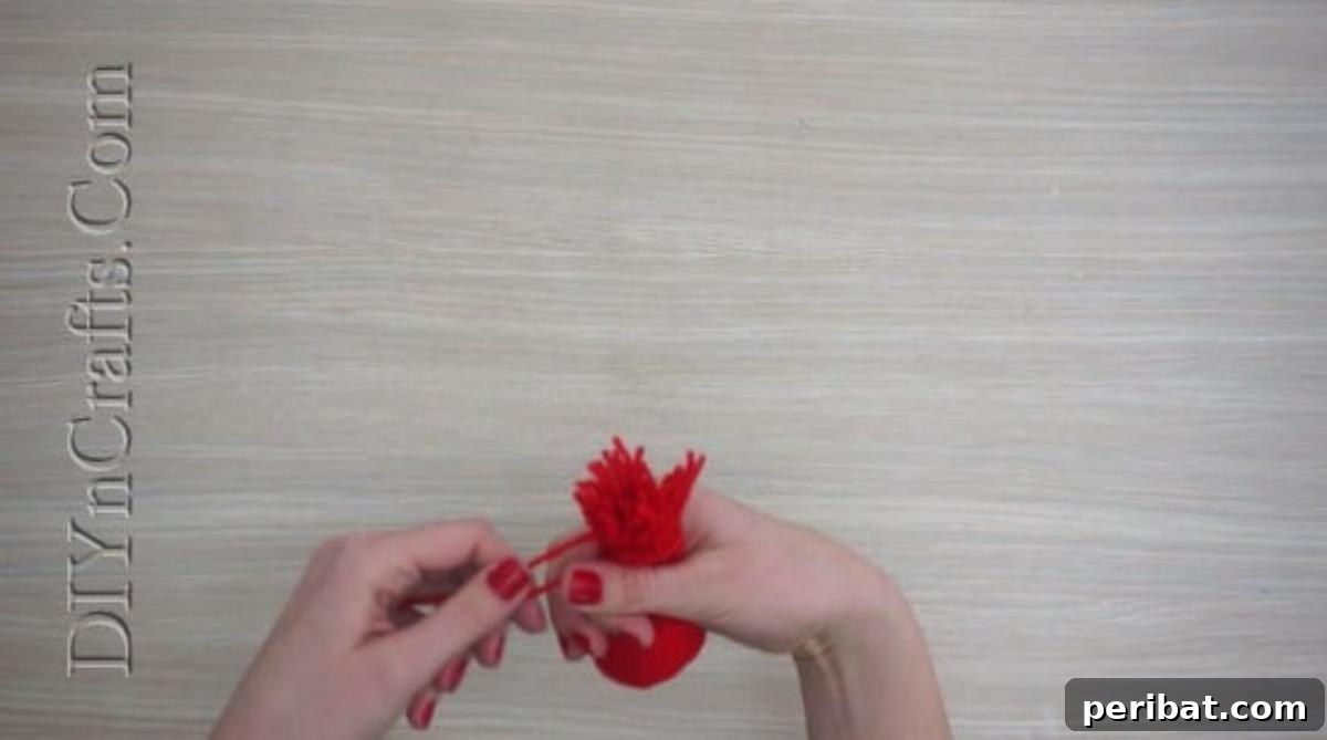 Hats - Gathering and tying the yarn ends to shape the top of a mini Christmas hat