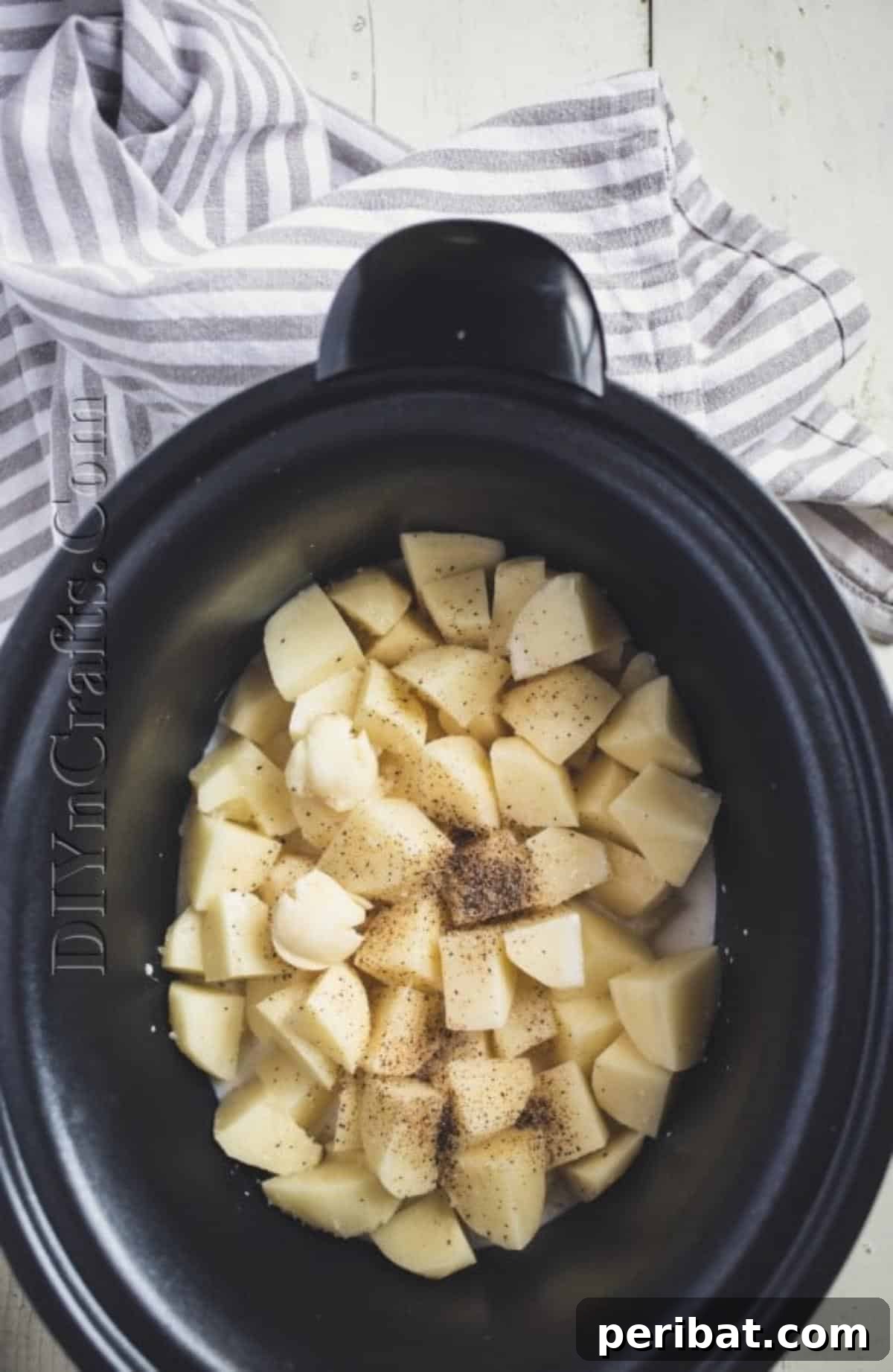 Cubed potatoes being placed into a slow cooker