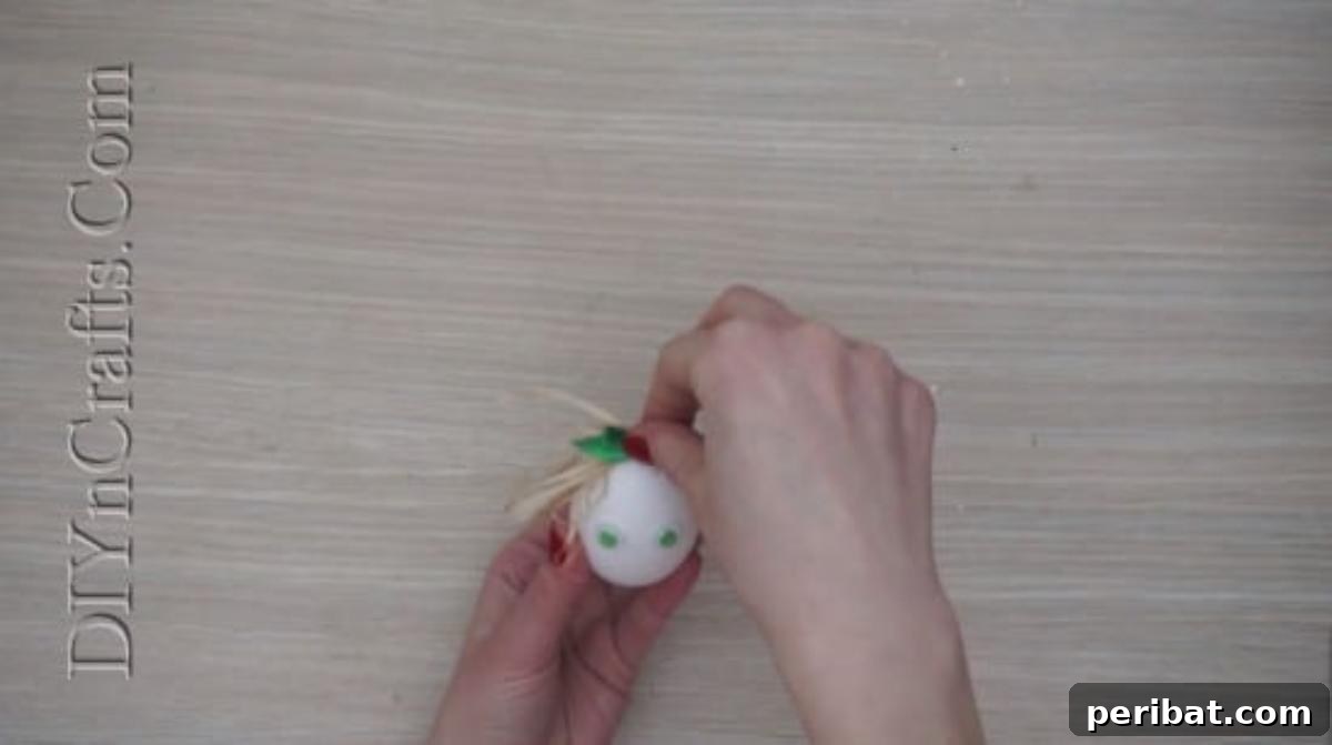 5 Brilliant & Easy Easter Egg Projects 18 Step 3: Attaching a cute decorative bow to the straw hair on the egg, adding a whimsical and personalized accessory to its character.