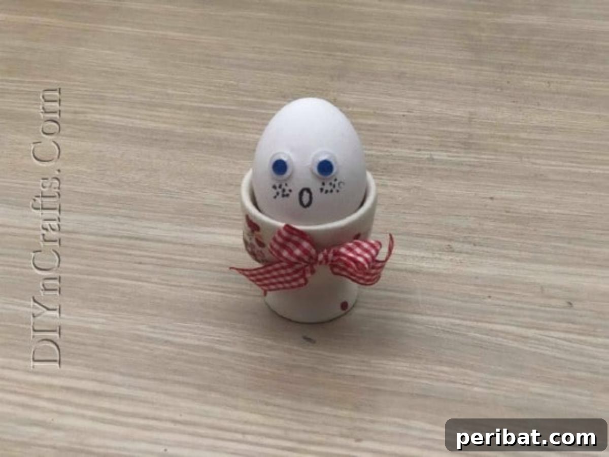 5 Brilliant & Easy Easter Egg Projects 23 Step 3: The finished Surprised Egg, with googly eyes and a drawn open mouth, displayed in a cup, ready to bring smiles and laughter.