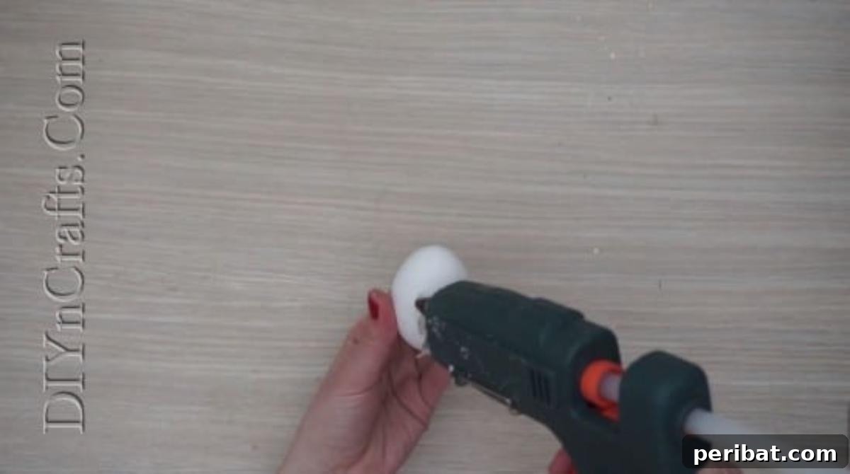 5 Brilliant & Easy Easter Egg Projects 7 Step 1: Attaching googly eyes and a folded paper beak to an egg with hot glue to begin creating a charming bird character for Easter.