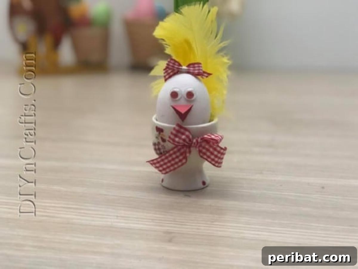 5 Brilliant & Easy Easter Egg Projects 10 Step 3: The completed Bird Egg, adorned with a bow and nestled in a decorative cup, showcasing its expressive googly eyes, beak, and feathered tail.